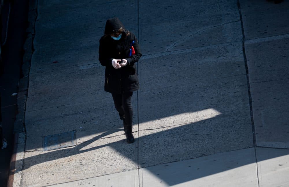 A woman wearing a mask and gloves tries to use her cellphone on April 22, 2020 in the Queens borough of New York City. - The US -- with nearly 45,000 deaths and more than 800,000 coronavirus infections -- is the hardest-hit country, and healthcare infrastructure in major hotspots such as New York City has struggled to cope. (Johannes Eisele/AFP via Getty Images)