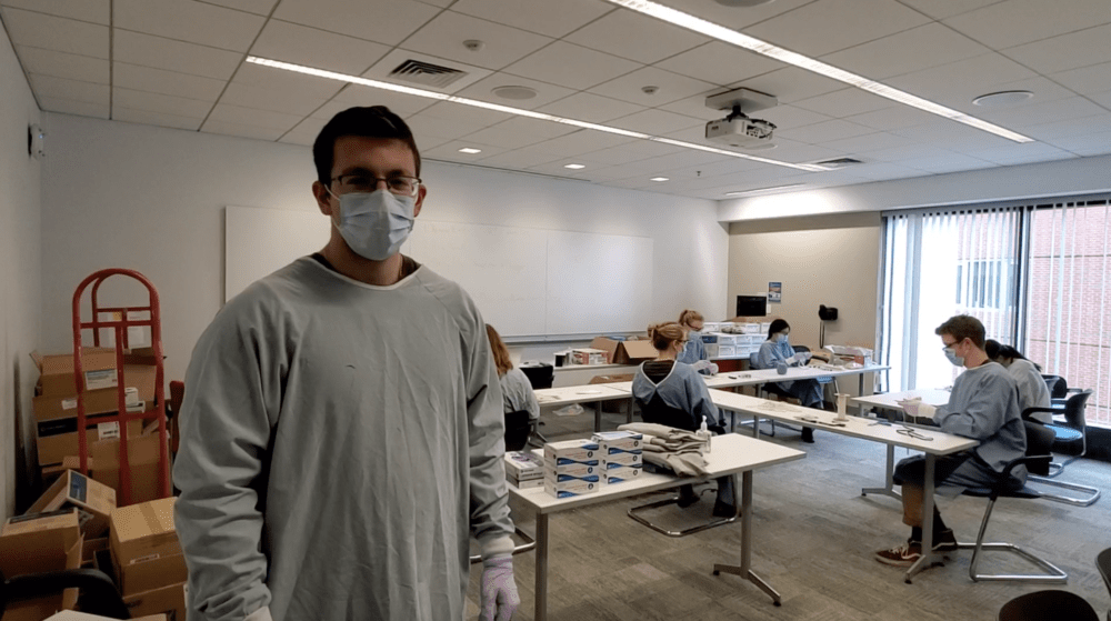 James Aronson oversees a makeshift assembly line for repairing expired N95 face masks at the Tufts Dental School (Screenshot of Tufts video)