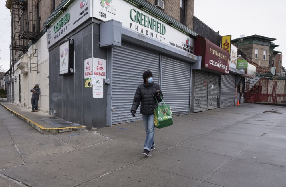 El viernes 3 de abril de 2020, una foto de una mujer caminando por las tiendas locales durante la pandemia del coronavirus en Nueva York. (Mark Lennihan/AP)