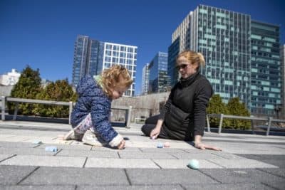 Two-year-old Thayer Elia and her mother Alaska draw with chalk on the ground at the Seaport Common. (Jesse Costa/WBUR)