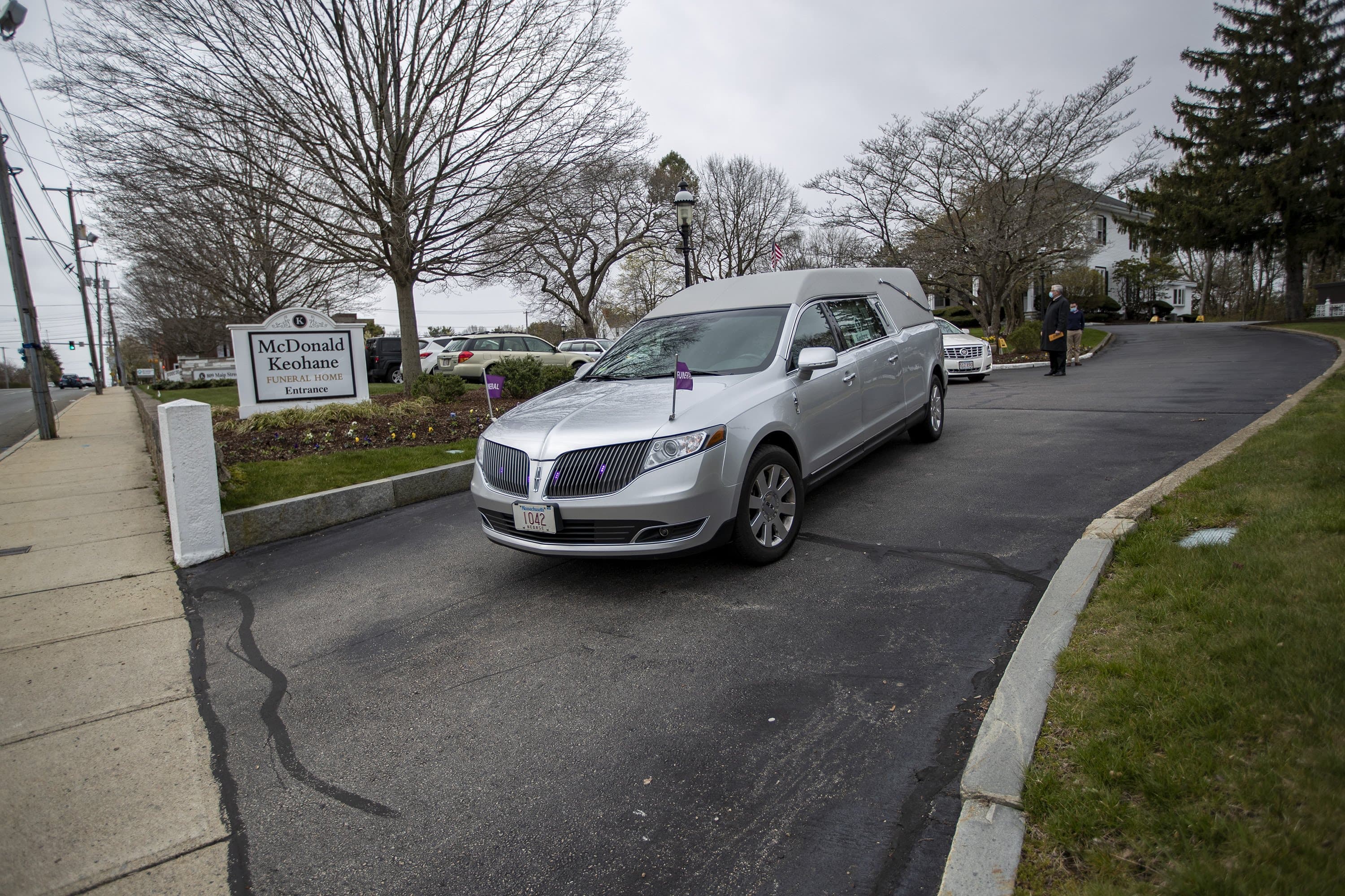 A hearse leaves the McDonald Keohane Funeral Home as it leads a procession to a nearby cemetery in Weymouth. (Jesse Costa/WBUR)
