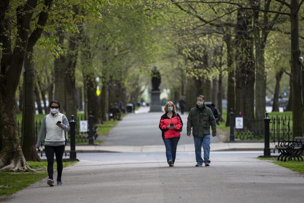 People walk along the Commonwealth Mall. on the first day masks are required to be worn in the state. (Jesse Costa/WBUR)