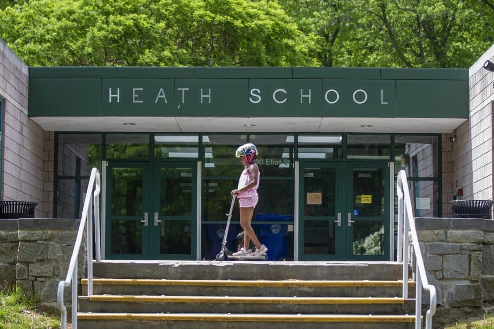 A young girl rides her scooter in front of the Heath School in Brookline. The Heath School is part of the Brookline Early Education Program, a program targeted by the proposed cuts. (Jesse Costa/WBUR)
