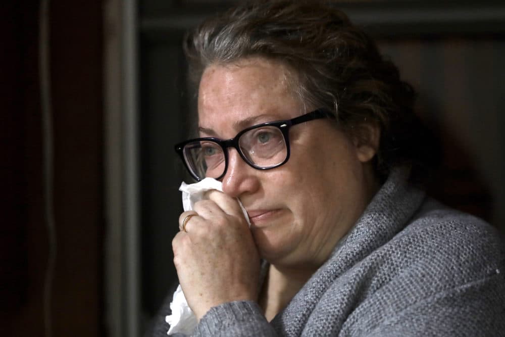 Susan Kenney, of Ware, Mass., who lost her father to the coronavirus, is tearful while speaking to a reporter from The Associated Press on the front porch of her home in Ware. (Steven Senne/AP)
