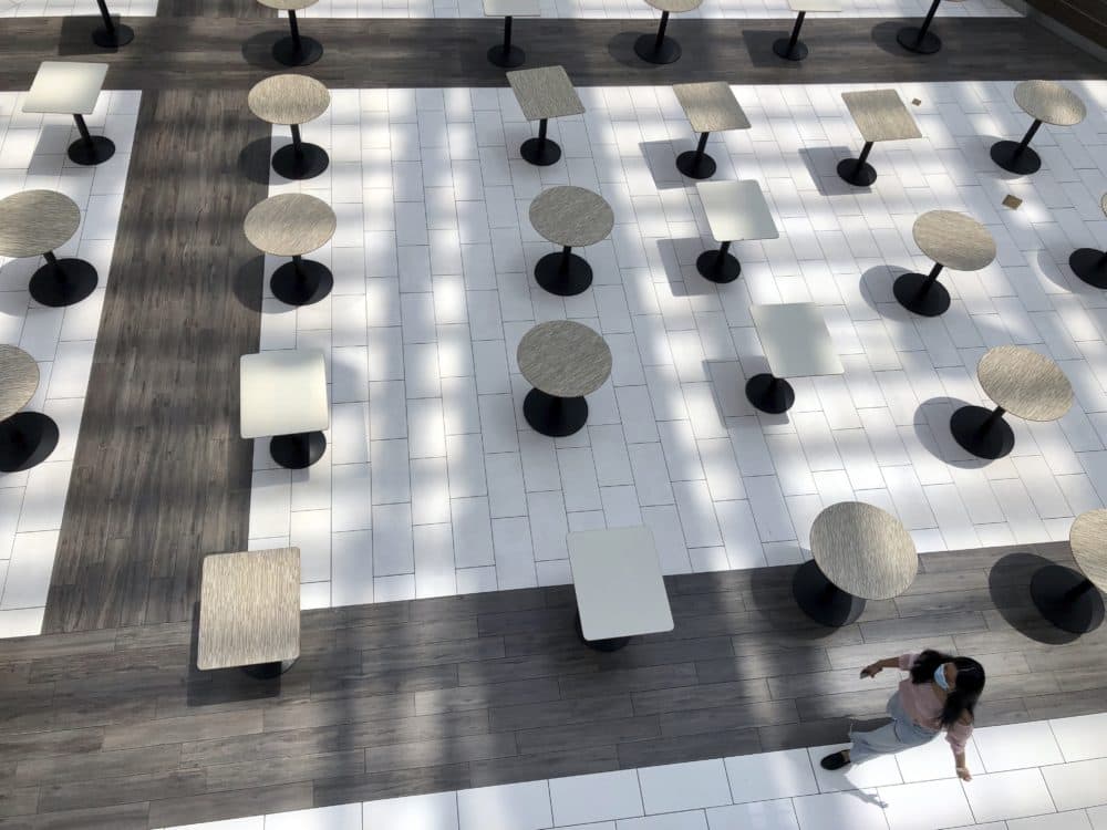 A woman wearing a protective mask walks through the mostly empty food court as Alabama's largest shopping mall, the Riverchase Galleria reopened in Hoover, Ala., Tuesday, May 5, 2020. Dozens of stores, including major retailers, remained closed as the mall opened for business for the first time during the coronavirus pandemic. (Jay Reeves/AP)
