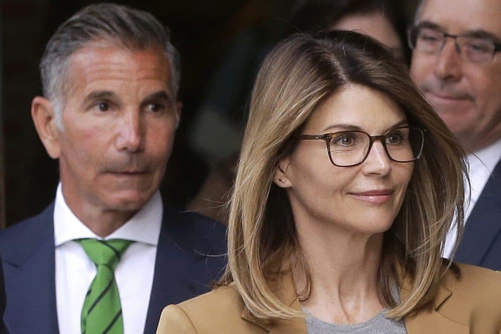 FILE - In this April 3, 2019, file photo, actress Lori Loughlin, front, and her husband, clothing designer Mossimo Giannulli, left, depart federal court in Boston after a hearing in a nationwide college admissions bribery scandal. (Steven Senne/AP File)
