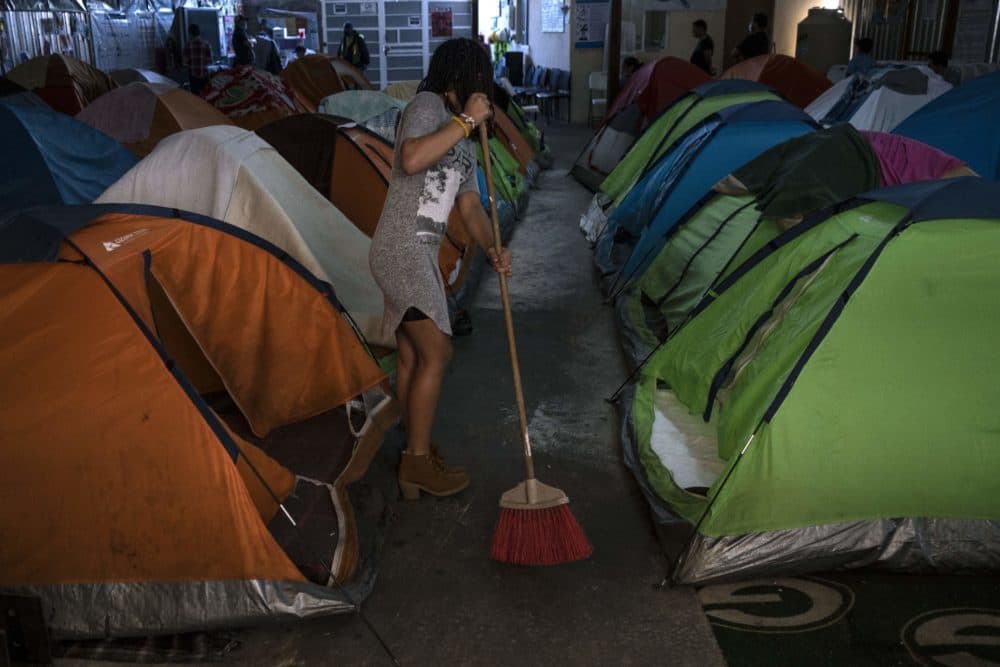 An asylum seeker staying at the Juventud 2000 migrant shelter in Tijuana, Baja California State, Mexico, sweeps the floor on April 3, 2020 as stronger cleaning measures are being implemented to fight the COVID-19 pandemic. (Guillermo Arias/AFP via Getty Images)