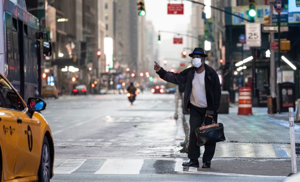 A man wearing a mask tries to catch a taxi at Times Square amid the Covid-19 pandemic on April 30, 2020 in New York City. (JOHANNES EISELE/AFP via Getty Images)