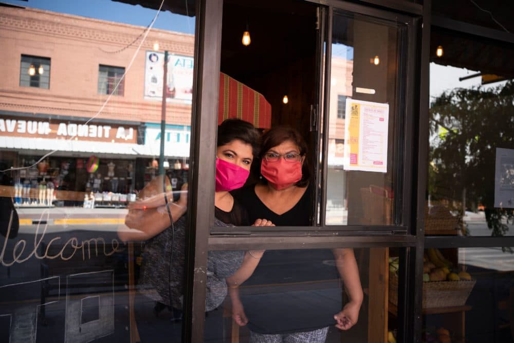 Vanessa Zubia-Meza and her mother Margie Zubia are pictured in the window of their new restaurant called El Paseo on May 18, 2020 in downtown El Paso, Texas. (PAUL RATJE/AFP via Getty Images)
