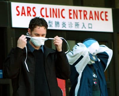Patients put on face masks as they leave the SARS (Severe Acute Respiratory Syndrome) clinic setup at Sunnybrook & Women's hospital in Toronto, Canada, on 31 March, 2003. (J.P. MOCZULSKI/AFP via Getty Images)