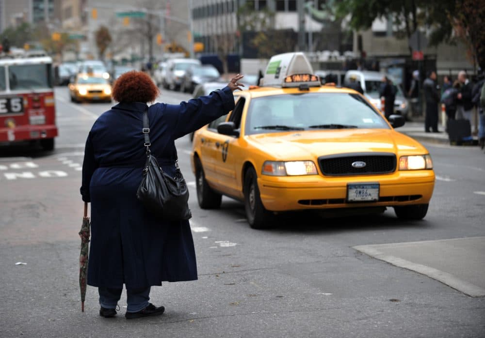 A woman tries to hail a taxi on First Avenue on October 31, 2012 in New York. (Stan Honda/AFP via Getty Images)