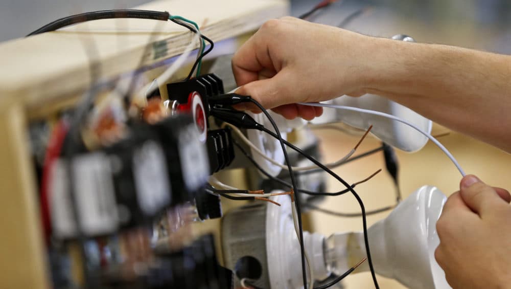A Washburn Tech electrical student tries to connect wires on a switch board to power on a light bulb.(Chris Neal/Shooter Imaging/Kansas News Service)