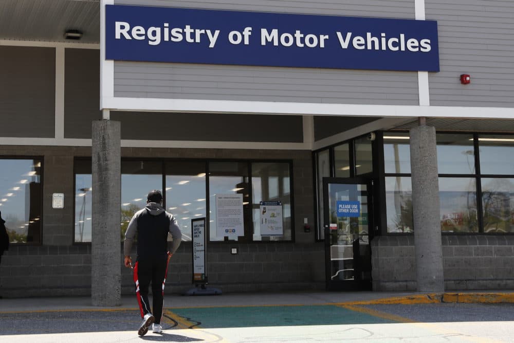 A man walks to the Commonwealth of Massachusetts Registry of Motor Vehicles office in Lawrence, Mass. on May 5. (Charles Krupa/AP)