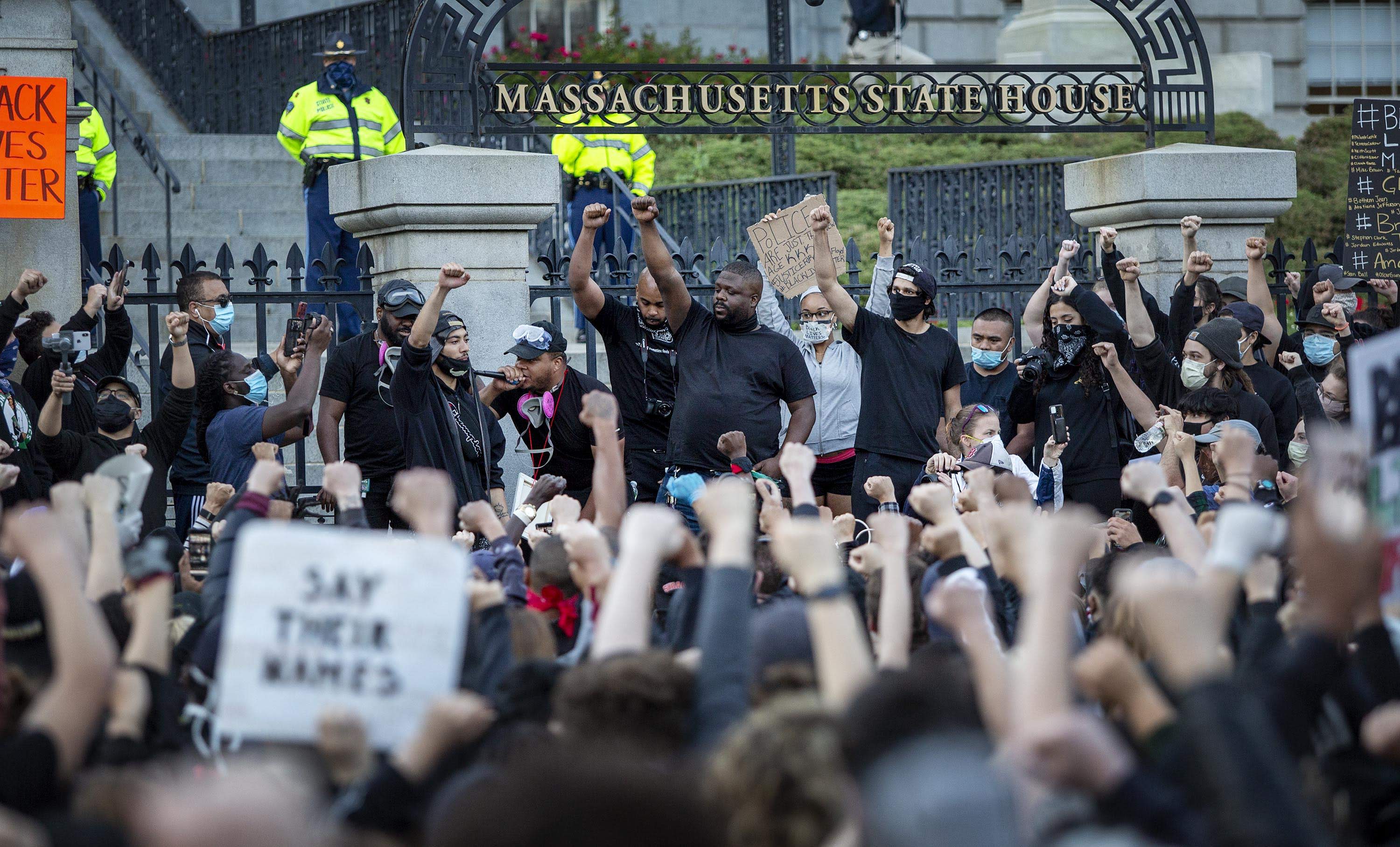Manifestantes levantan su puño en las afueras de la Cámara de Representantes (Robin Lubbock/WBUR)