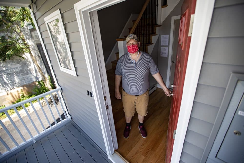 Ed Alger stands in the doorway of the building he moved into recently, which is operated by Father Bill's & MainSpring. The six previously homeless men living in the Brockton property will get on-site support services. (Jesse Costa/WBUR)