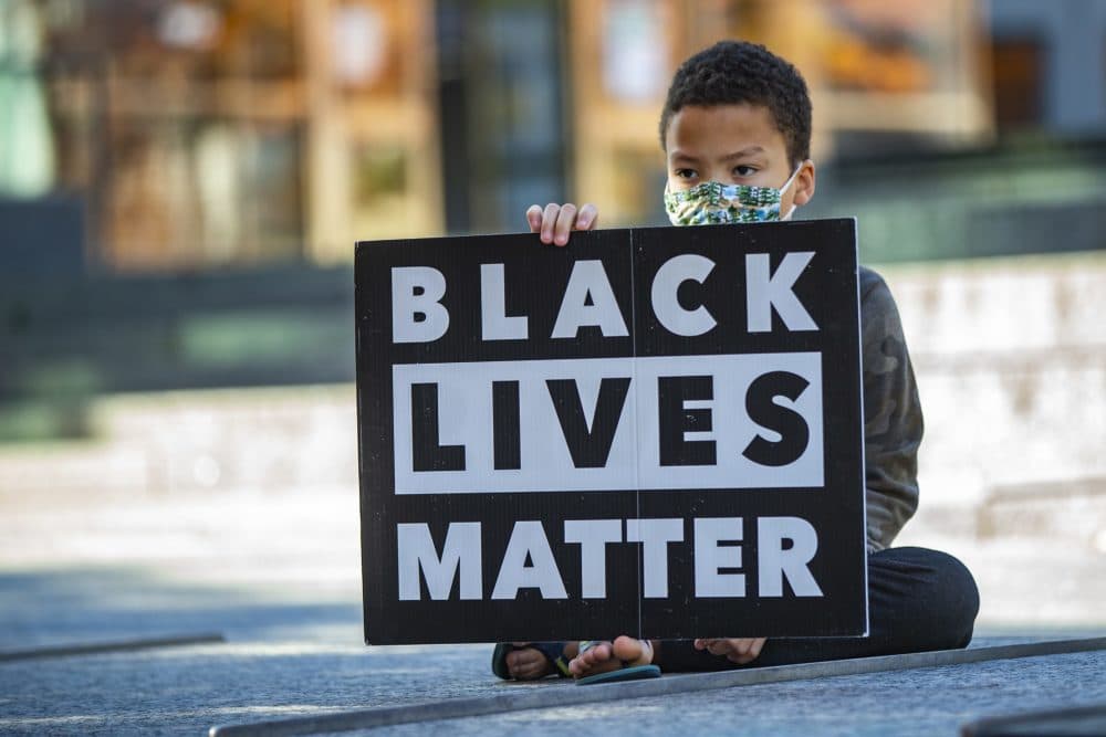 10-year-old Marcus Bilodeau holds a Black Lives Matter sign during a demonstration at City Hall Plaza in November of 2020. (Jesse Costa/WBUR)