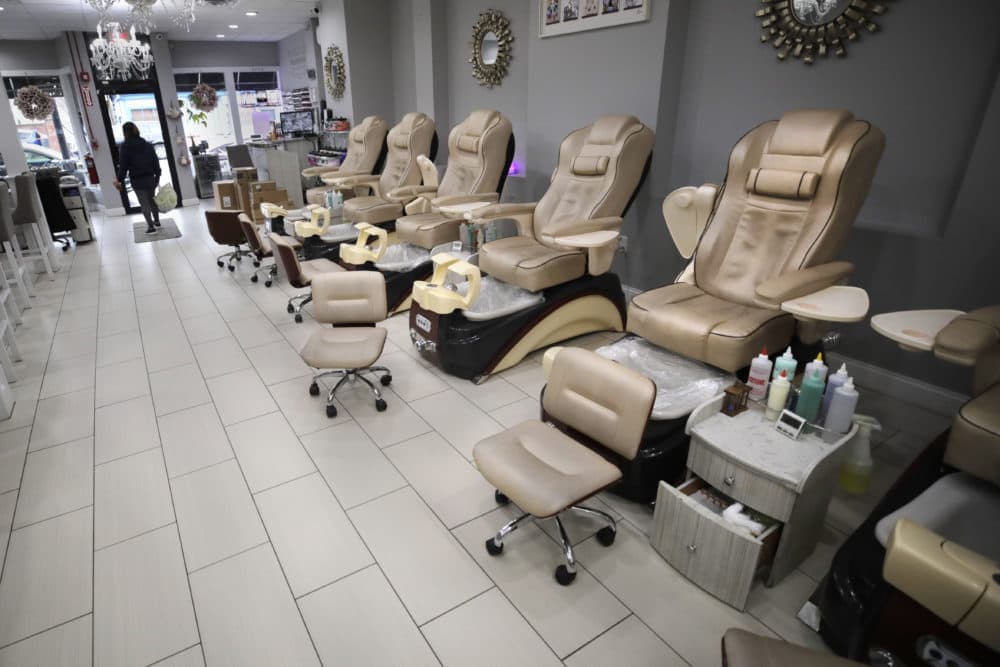 A woman leaves an empty nail salon in South Boston on March 17. (Charles Krupa/AP)