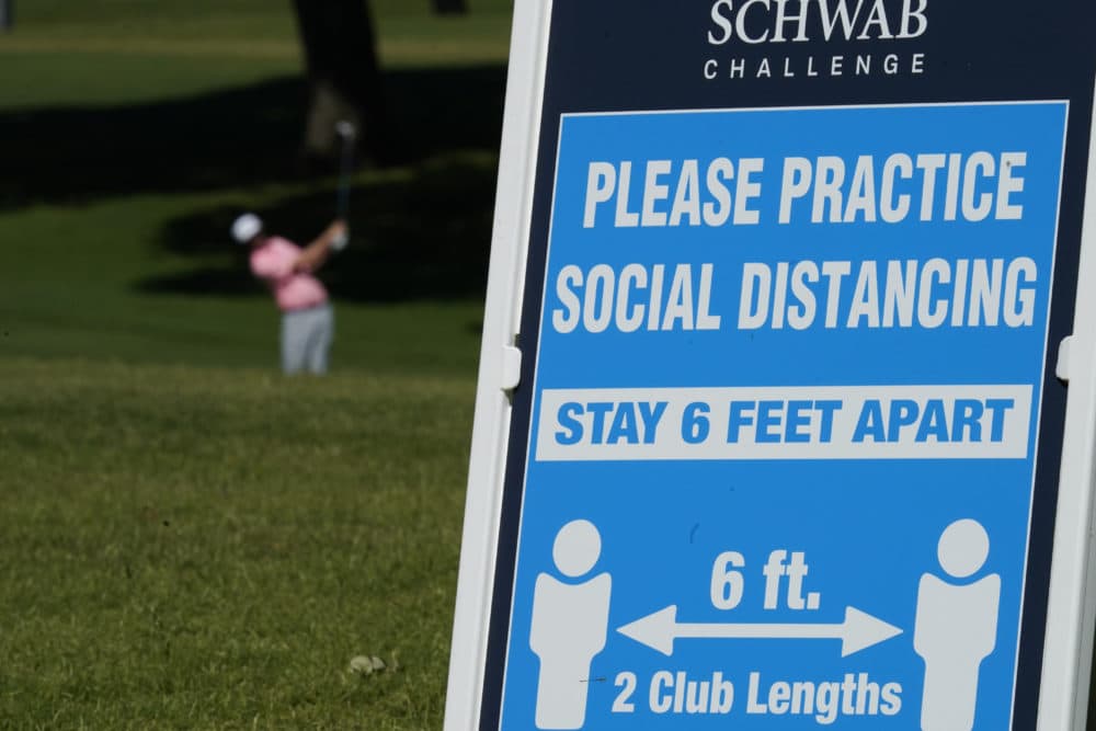 Signs remind golfers of social distancing rules during the first round of the Charles Schwab Challenge golf tournament at the Colonial Country Club in Fort Worth, Texas, Thursday, June 11, 2020. (David J. Phillip/AP)