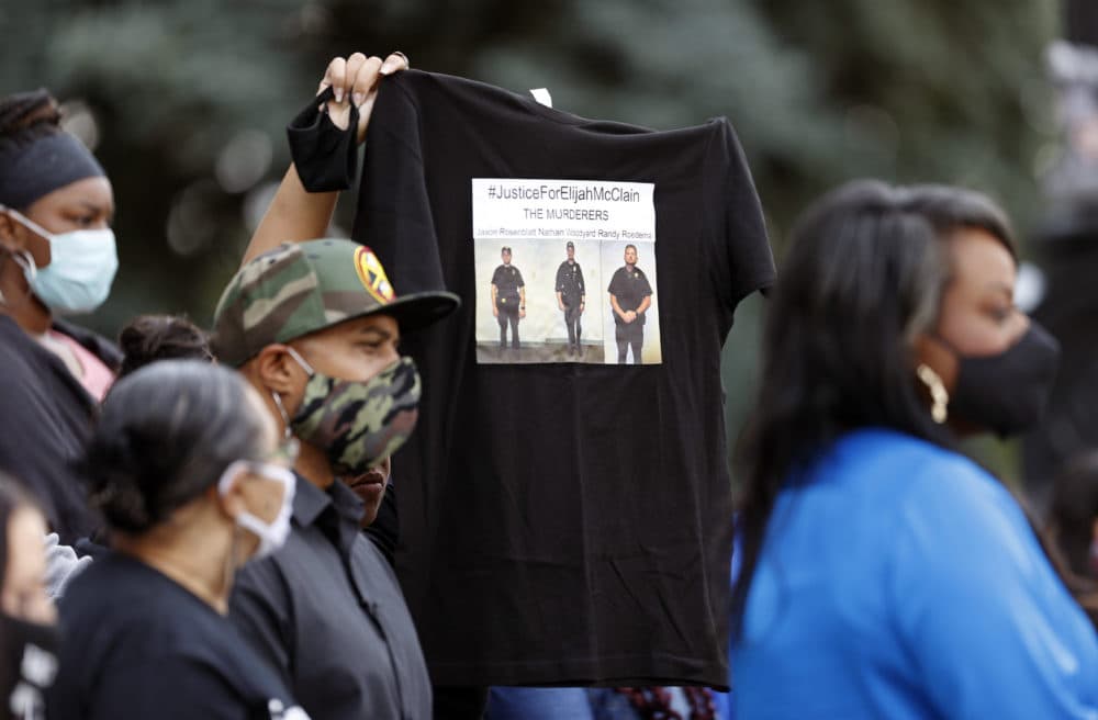 A supporter holds up a shirt to call attention to the death of Elijah McClain in August 2019 in Aurora, Colorado., during a news conference after Colorado Gov. Jared Polis signed a broad police accountability bill on June 19, 2020. (David Zalubowski/AP)