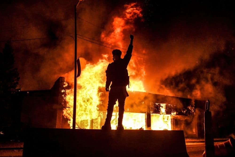 A protester reacts standing in front of a building set on fire during a demonstration in Minneapolis on May 29, 2020, over the death of George Floyd at the hands of police. (Chandan Khanna/AFP/Getty Images)