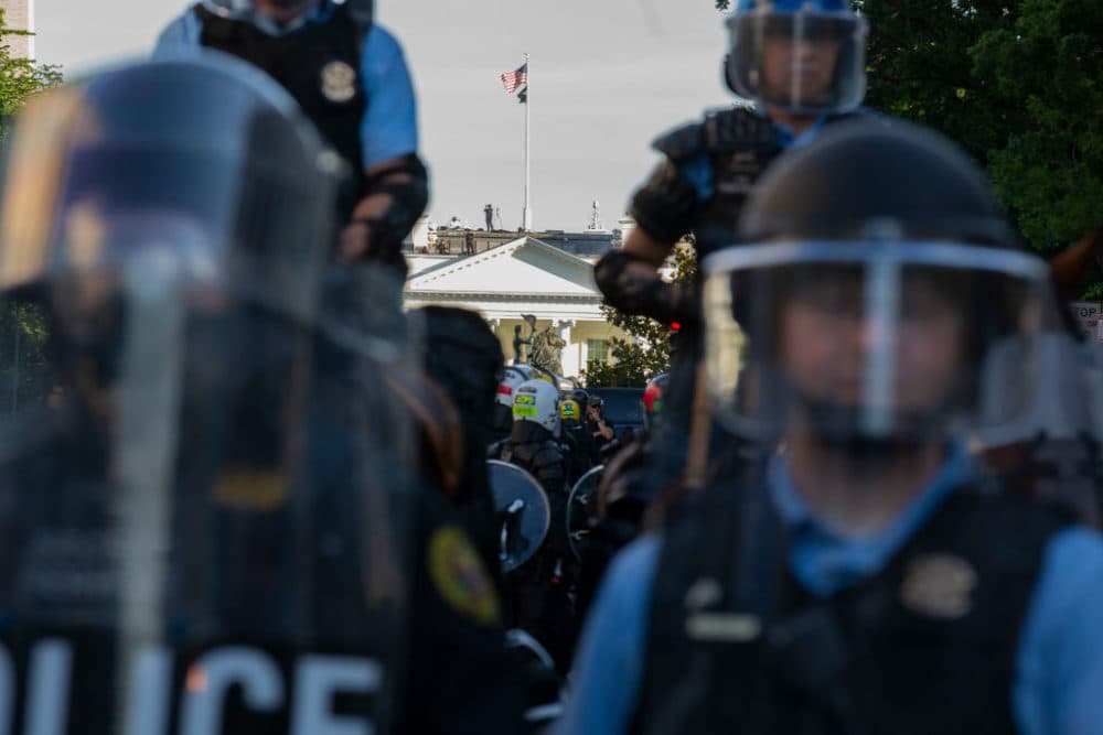 The White House is seen behind a line of park police officers wearing riot gear. (Jose Luis Magana/AFP/Getty Images)