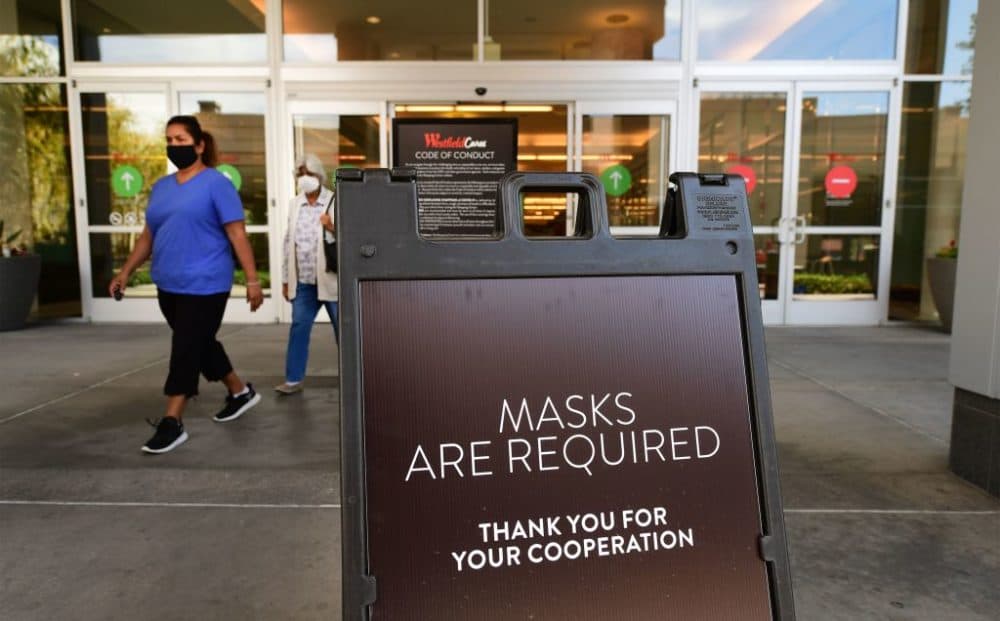 A sign at a shopping mall in Santa Anita, California, reminds people of the mask requirement.(Frederic J. Brown/AFP/Getty Images)