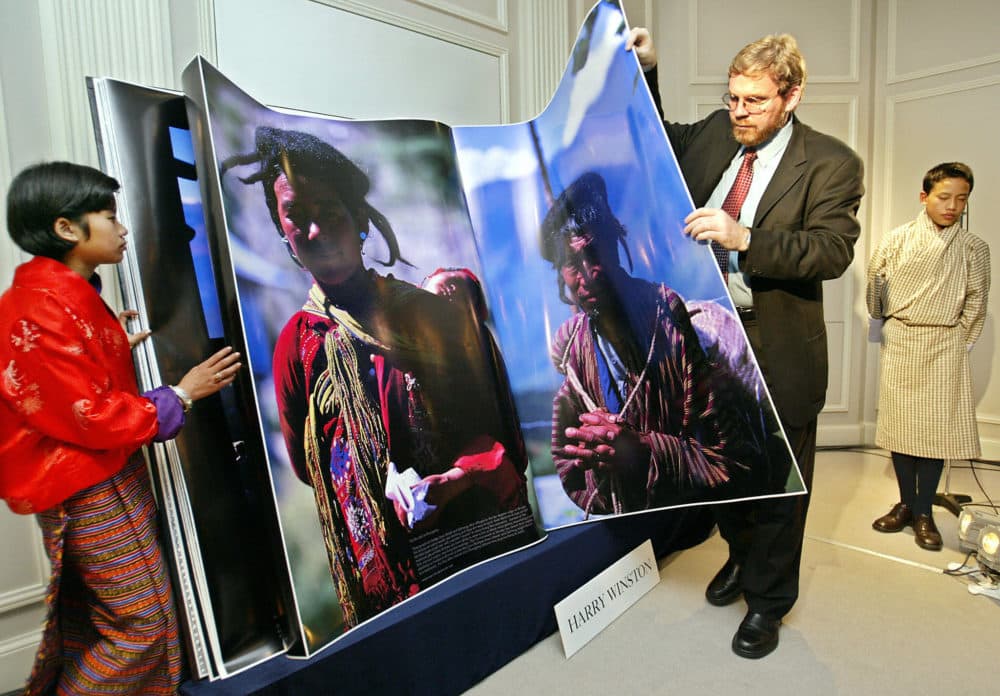 In this 2003 photo, MIT's Michael Hawley turns a page of his book &quot;Bhutan, A Visual Odyssey Across the Kingdom&quot; to introduce the Himalayan country while Bhutanese boy Gyelsey Loday (R) and girl Choki Lhamo (L) look on during a preview in Tokyo. (TORU YAMANAKA/AFP via Getty Images)