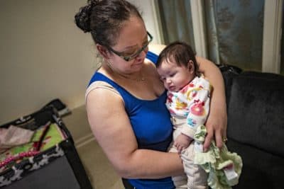 Carolina, with her 4-month-old daughter at her apartment in East Boston. (Jesse Costa/WBUR)