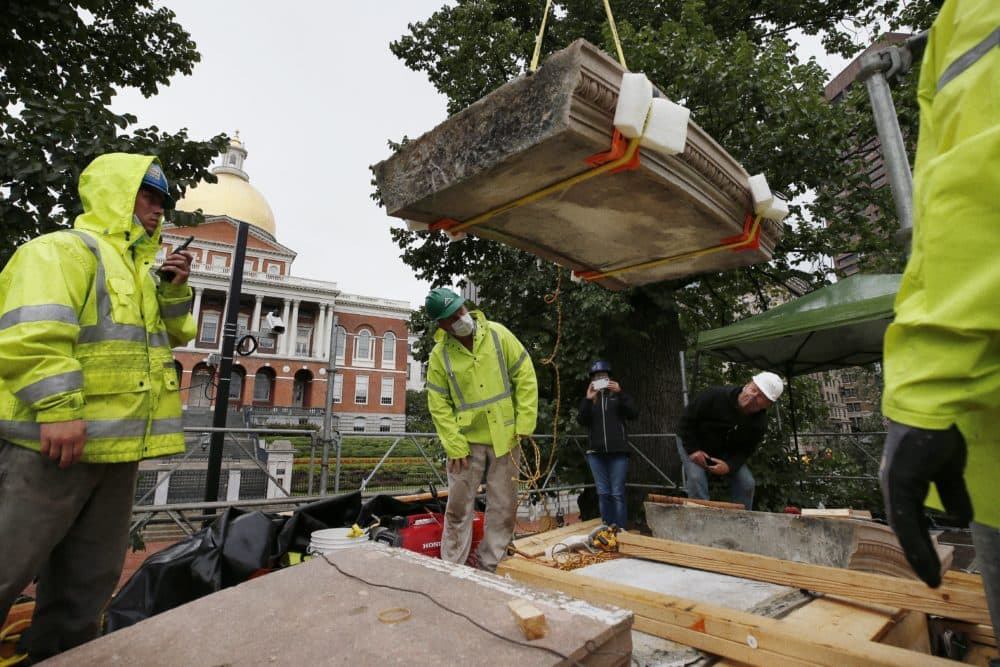 Workers inspect the top cornice stone as it is lifted from the Shaw 54th Regiment memorial opposite the State House, July 17, 2020, in Boston. Amid the national reckoning on racism, the memorial to the first Black regiment of the Union Army, the Civil War unit popularized in the movie &quot;Glory,” is facing scrutiny.(Michael Dwyer/AP)