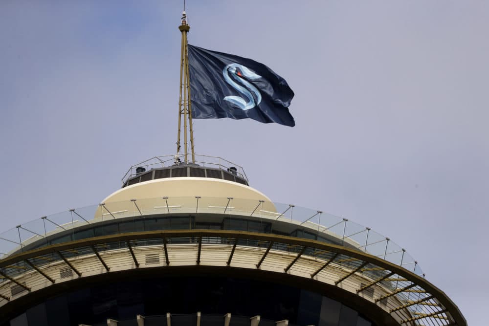 A flag with the new logo for the newly-named Seattle NHL team, the Seattle Kraken, flies atop the Space Needle. (Elaine Thompson/AP)