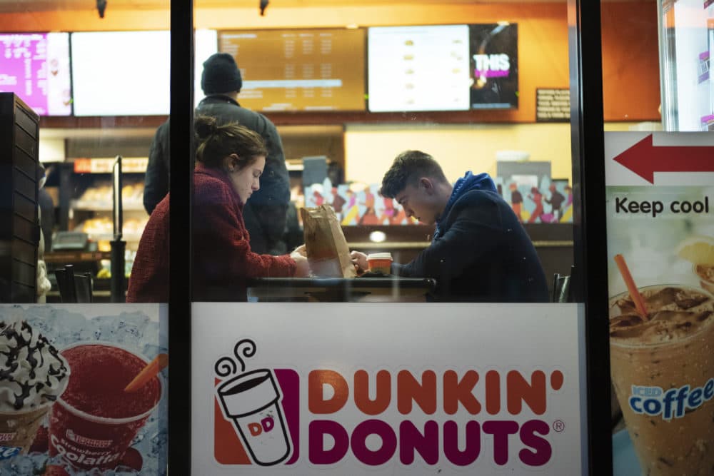 In this Jan. 30, 2019 photo, customers sit inside a Dunkin' Donuts in New York. (Mark Lennihan/AP)