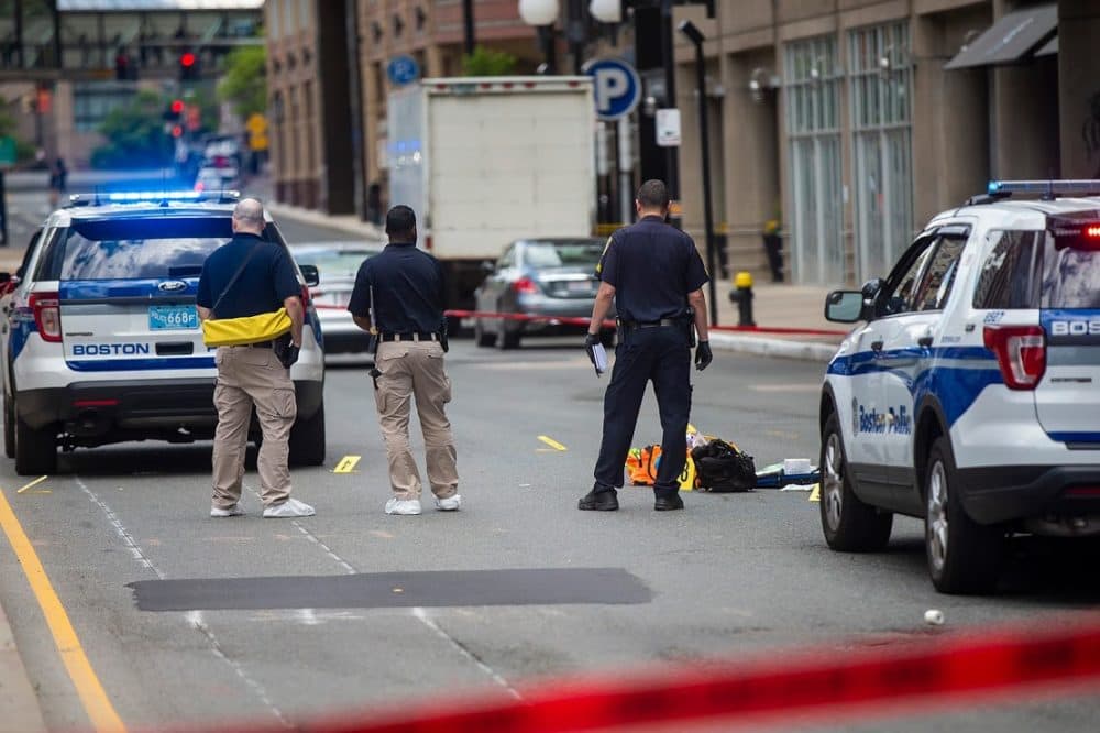 Boston Police examine the evidence on the ground in front of the Colonnade Hotel on Huntington Ave. following a shooting that claimed the life of Boston taxi driver Luckinson Oruma in June, 2019. (Jesse Costa/WBUR)