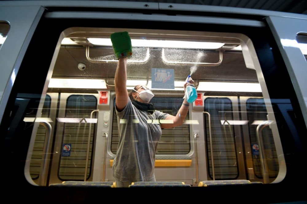 A cleaner wearing gloves and a protective face mask disinfects and cleans a metro train. (Damien Meyer/AFP via Getty Images)