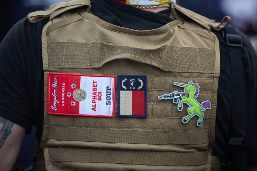 A member of the far-right militia, Boogaloo Bois, walks next to protestors demonstrating outside Charlotte Mecklenburg Police Department Metro Division 2 just outside of downtown Charlotte, North Carolina, on May 29, 2020. (Logan Cyrus/AFP via Getty Images)