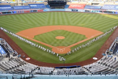 Members of the Los Angeles Dodgers and the San Francisco Giants kneel prior to the national anthem before their game at Dodger Stadium on July 23, 2020 in Los Angeles, California. (Harry How/Getty Images)