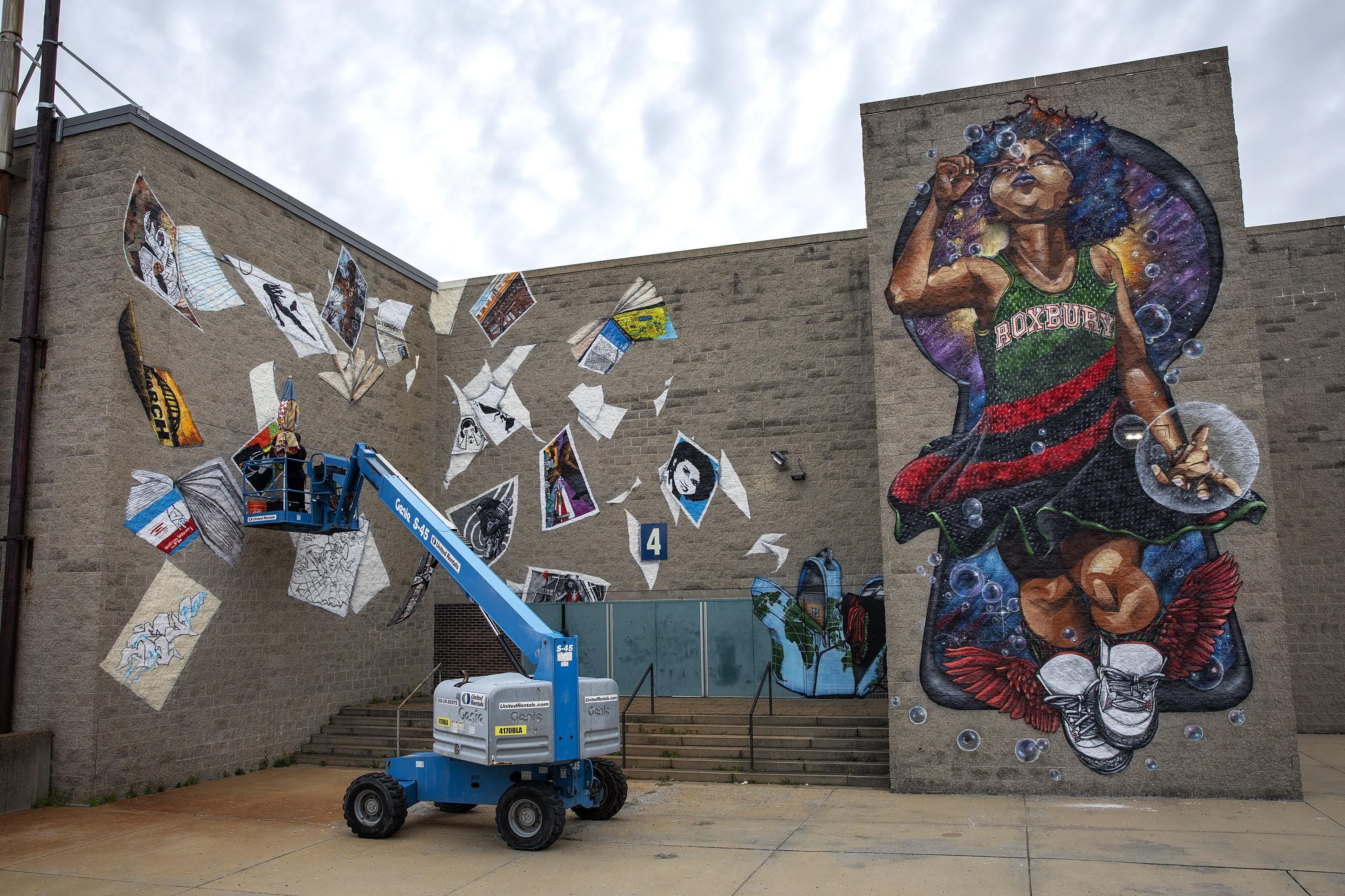 Rob &quot;Problak&quot; Gibbs works on the third wall of the &quot;Breathe Life&quot; mural at Madison Park Technical Vocational High School, as the project nears completion. (Robin Lubbock/WBUR)