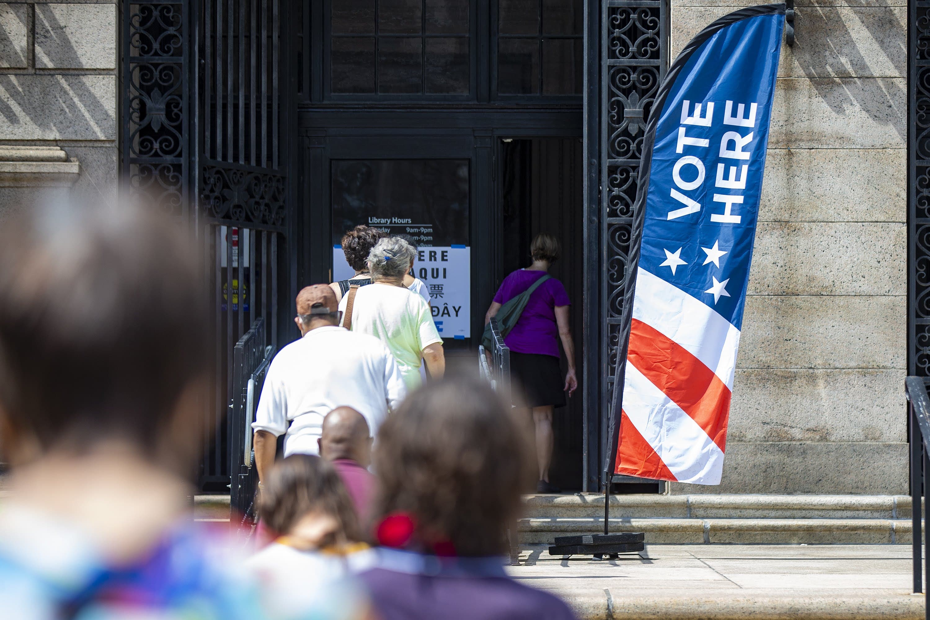 Voters stand in line six feet apart outside the Boston Public Library on the first day of early voting, Aug. 22, for the Massachusetts primary. (Jesse Costa/WBUR)