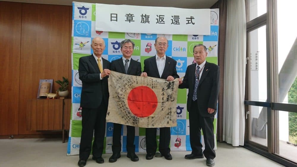 The WWII flag submitted by Greg Murphy of Portland was traced back to a fallen Japanese soldier who carried it into battle in 1944. The mayor of Chita City, Japan, second from right, hosted a ceremony in 2019 where a nephew of the soldier, second from left, accepted the returned flag. (Courtesy of Obon Society, 2019)