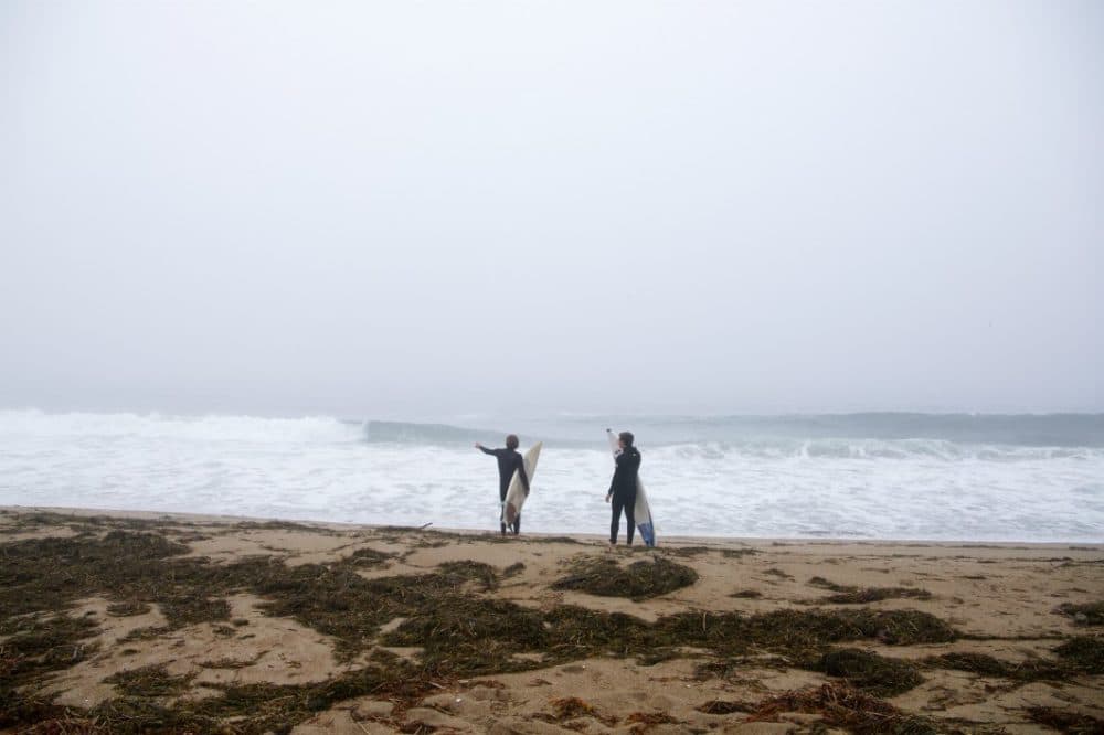 Two surfers on a Maine beach check the surf in July 2020. (Chris Ritter)