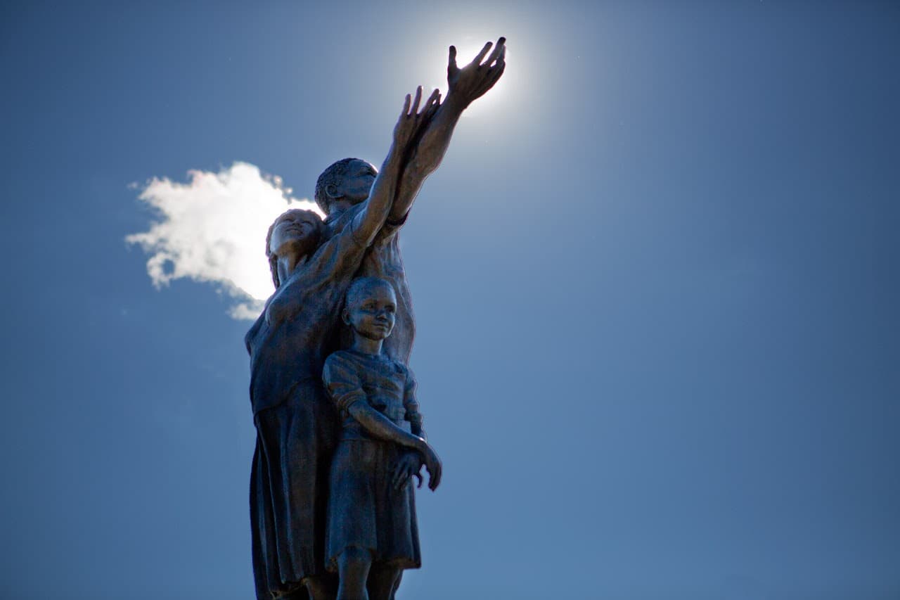 &quot;Rise,&quot; the 19-foot bronze sculpture by former Mattapan resident Fern Cunningham-Terry, stands at the gateway to Mattapan Square on Blue Hill Avenue. (Jesse Costa/WBUR)