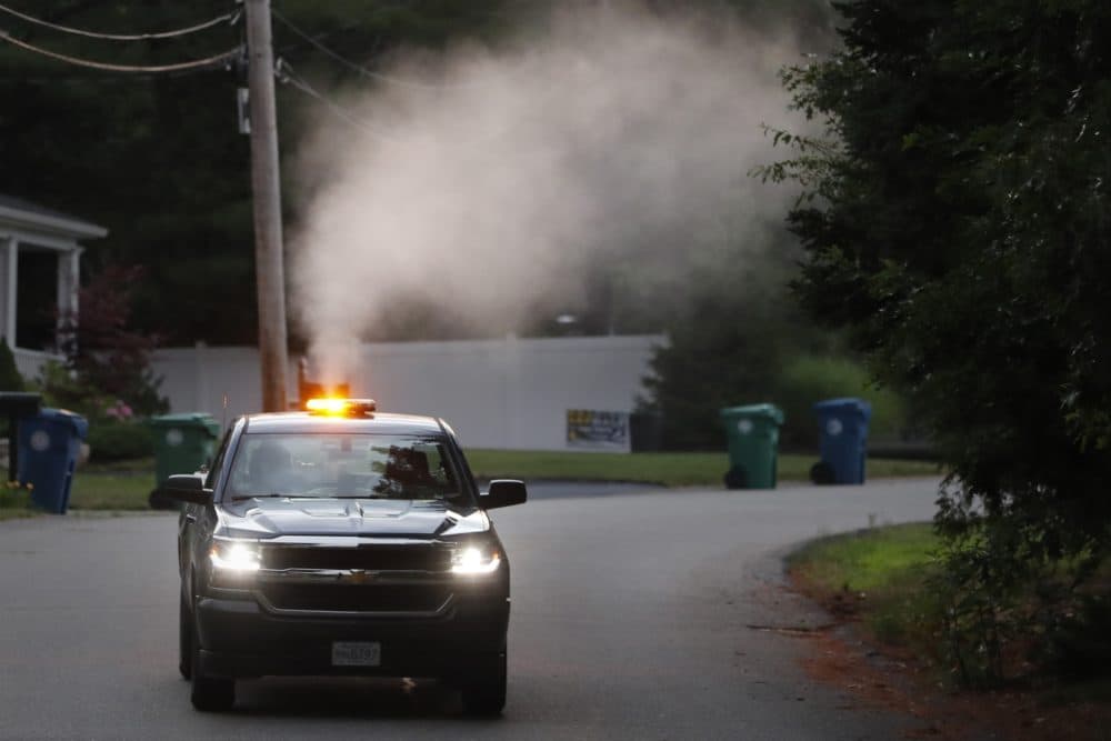 A crew from the East Middlesex Mosquito Control Project spray to control mosquitos from a pick-up truck on July 8, 2020, while driving through a neighborhood in Burlington, Mass. Officials are preparing for another summer with a high number of cases of eastern equine encephalitis. (Charles Krupa/AP)