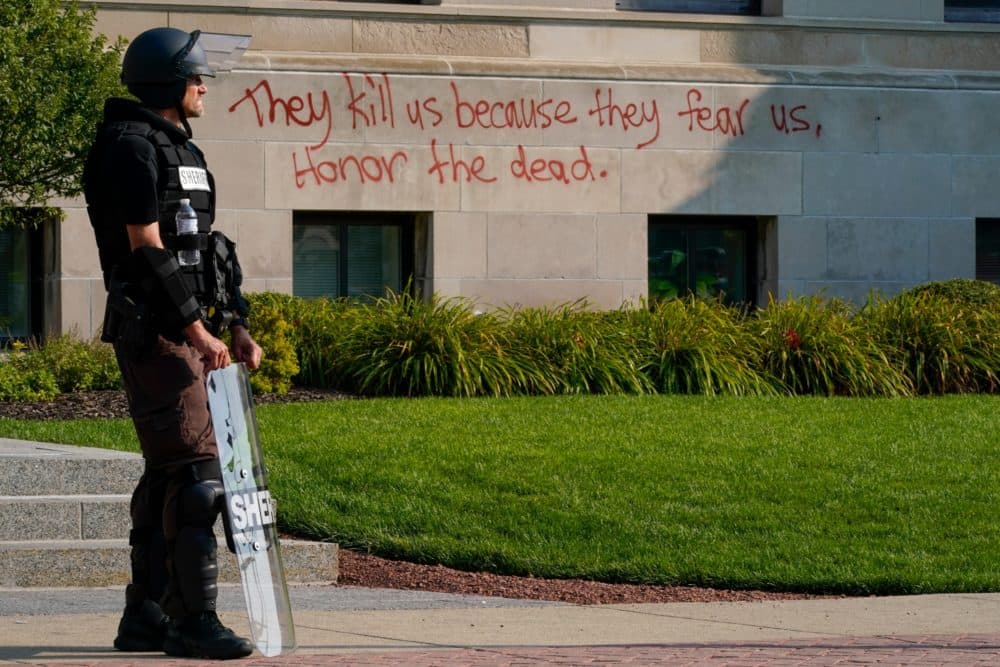 Police in riot gear stand outside the Kenosha County Court House on Monday, Aug. 24, in Kenosha, Wisconsin. Protests broke out late Sunday night after police shot a Black man earlier in the day. (Morry Gash/AP)