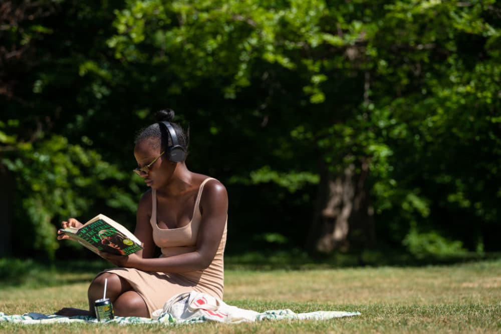 A woman reads a book as people enjoy the hot weather in Greenwich Park, London, as people flock to parks and beaches with lockdown measures eased. (Photo by Dominic Lipinski/PA Images via Getty Images)