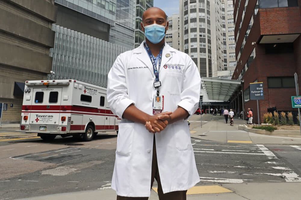 Alister Martin, an emergency room doctor at Massachusetts General Hospital, poses outside the hospital, Friday, Aug. 7, 2020, in Boston. Martin founded the organization &quot;VotER&quot; to provide medical professionals voter registration resources for patients who are unregistered voters. (Charles Krupa/AP)
