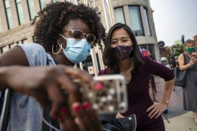 A supporter snaps a selfie with mayoral candidate Michelle Wu during a campaign appearance in Nubian Square. (Jesse Coista/WBUR)