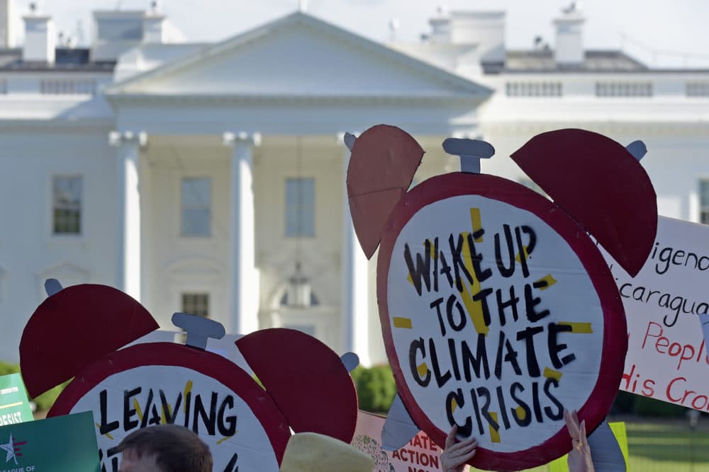 In this June 1, 2017 file photo, protesters gather outside the White House in Washington to protest President Donald Trump's decision to withdraw the Unites States from the Paris climate change accord. (Susan Walsh/AP)