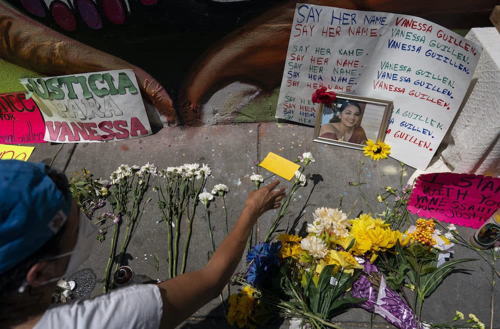 Frida Larios places flowers near of photograph of slain Army Spc. Vanessa Guillen at the base of a mural of Guillen on 14th Street NW in Washington, Monday, July 13, 2020. (Carolyn Kaster/AP Photo)