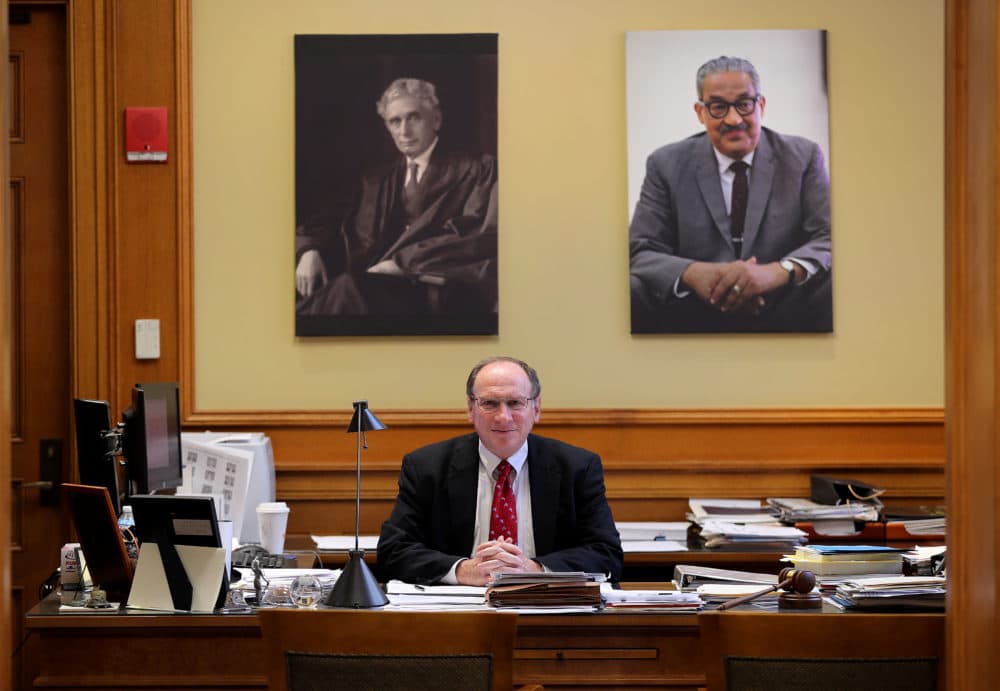 Ralph Gants, the Massachusetts Supreme Judicial Courts chief justice, poses for a portrait at his desk at the John Adams Courthouse in Boston under portraits of Justice Louis Brandeis, left, and Justice Thurgood Marshall, right, on May 16, 2019. Gants died after suffering a heart attack earlier this month, the court said Monday, Sept. 14, 2020. (John Tlumacki/The Boston Globe via Getty Images)