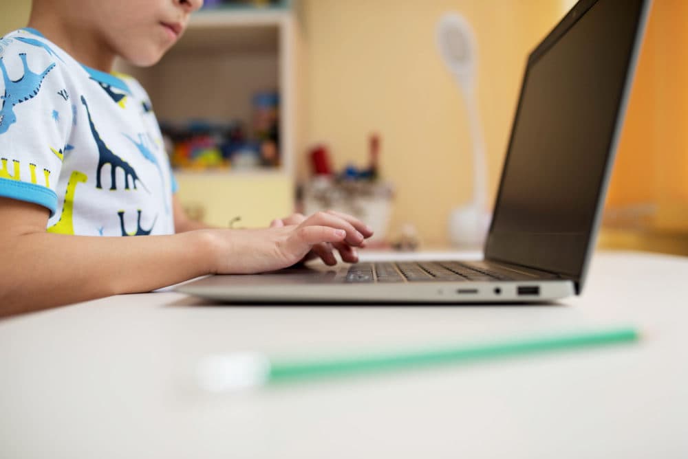 A child types on a laptop. (Getty Images)