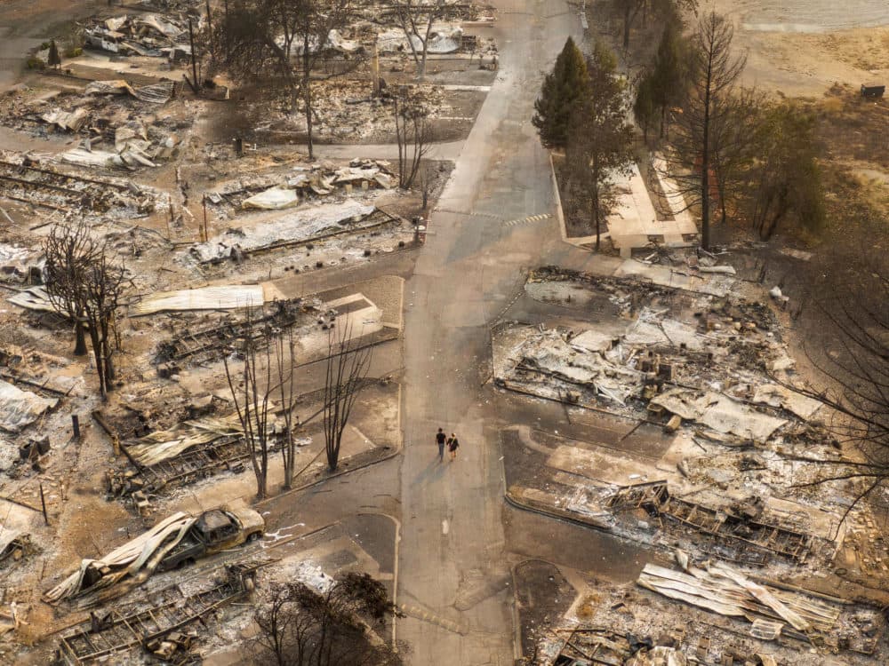 In this aerial view from a drone, people walk through a mobile home park destroyed by fire on September 10, 2020 in Phoenix, Oregon. (David Ryder/Getty Images)